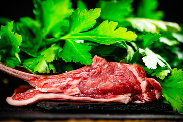 Fresh raw rack of lamb on a stone board with parsley. 