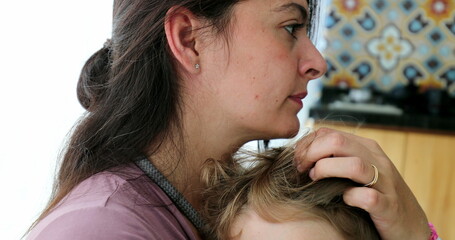 Mother caressing child hair mom cuddling toddler