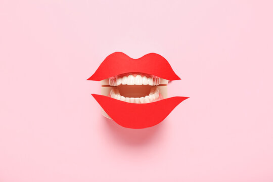 Jaw model with paper lips on pink background