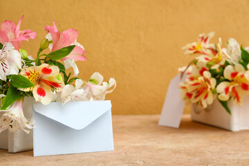 Drawers with beautiful alstroemeria flowers and envelope on color background. Mother's day celebration
