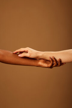 Cropped picture of a multicultural girls touching each other hands.