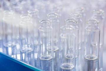 Close up view - medical empty glass bottles in showcase at pharmaceutical exhibition, pharmacy laboratory. Pharma industry, science, medicine, experiment, chemistry, research and healthcare concept