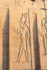 Exterior facade of the Edfu temple, with the stone carved with hieroglyphics.
