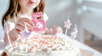 Big pink 5 number candle on homemade cake. Creative congratulations on five years for child girl....