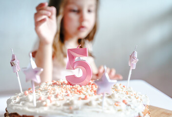 Big pink 5 number candle on homemade cake. Creative congratulations on five years for child girl. Festive decoration for 5th birthday, topping, dressing. Merry home holiday, party with mom, family