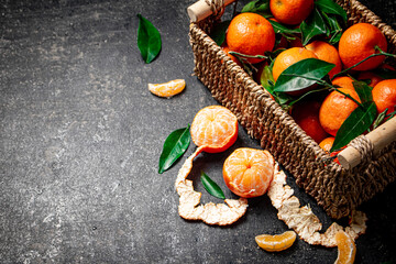 Ripe tangerines with leaves in a basket. 