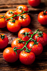 Fresh tomatoes on a branch on the table. 
