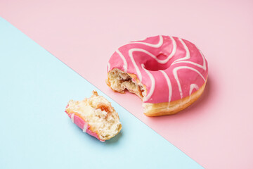 Bitten donut on pink and blue background
