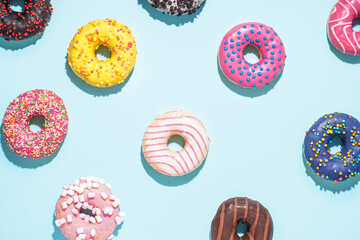 Different delicious donuts on blue background