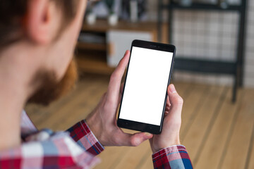 Mock up, copyspace, template and technology concept. Man looking at black vertical smartphone with white blank screen. Close up view of man hands with smart phone mobile device - mockup image