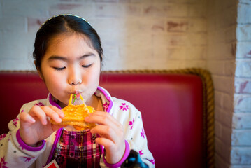 Young girl eating grilled cheese with cheese stretching