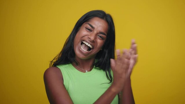 Young black woman applauding after presentation in a conference over isolated background. Yellow screen chroma key video. People lifestyle concept. Indian girl cheering clapping hands.