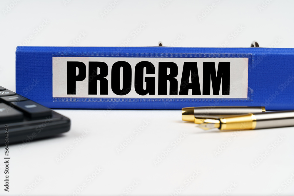 Poster on a white surface, a calculator, a pen and a folder with the inscription - program