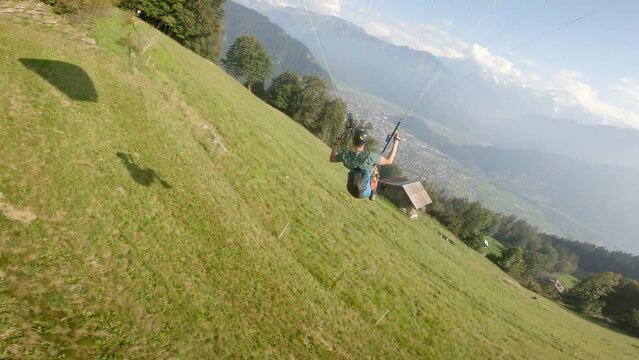 Extreme paragliding launch in the Swiss Alps on a sunny day. Adventure, freedom, and mountain landscape concept.
