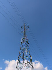 Fototapeta premium Electricity pylon and wires on a blue sky