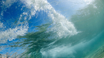 Fototapeta na wymiar Underwater view of underneath a wave.