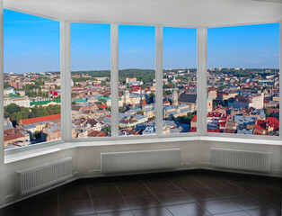 Panoramic window with view of city buildings. Cityscape seen from room window