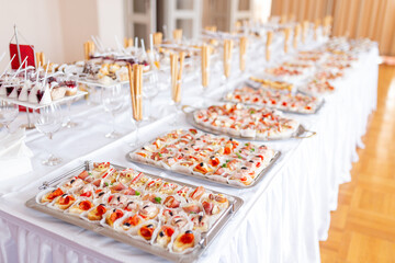 Close up of various canapes served in plates on buffet table.