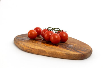 Cherry tomatoes on wooden chopping board on white background isolated