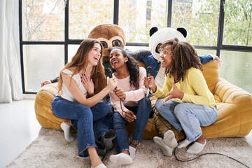 Two unrecognizable woman with animal mask bear panda holding big heart at home - Valentine's day...