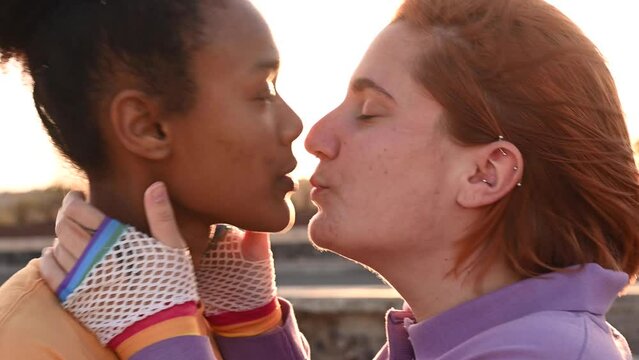 Romantic multiethnic lesbian couple kissing on street