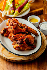 
Chicken wings. Buffalo chicken wings. American cuisine of chicken wings deep-fried, dipped in buffalo sauce made of vinegar,  cayenne hot sauce and butter. Served with celery, carrots, blue cheese.
