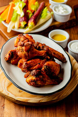 
Chicken wings. Buffalo chicken wings. American cuisine of chicken wings deep-fried, dipped in buffalo sauce made of vinegar,  cayenne hot sauce and butter. Served with celery, carrots, blue cheese.