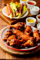 
Chicken wings. Buffalo chicken wings. American cuisine of chicken wings deep-fried, dipped in buffalo sauce made of vinegar,  cayenne hot sauce and butter. Served with celery, carrots, blue cheese.