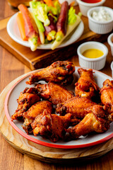 
Chicken wings. Buffalo chicken wings. American cuisine of chicken wings deep-fried, dipped in buffalo sauce made of vinegar,  cayenne hot sauce and butter. Served with celery, carrots, blue cheese.