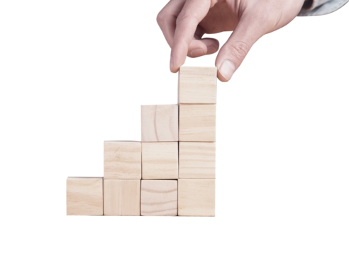 Escalera de bloques. Bloques escalando hacia arriba. Mano sujetando bloques. Construcción. Camino al éxito. Crecimiento. Emprendimiento.