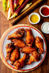 
Chicken wings. Buffalo chicken wings. American cuisine of chicken wings deep-fried, dipped in buffalo sauce made of vinegar,  cayenne hot sauce and butter. Served with celery, carrots, blue cheese.