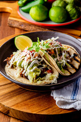 Tacos. Crispy flour and corn tortillas filled with sausage, bacon, beef, cheese, sour cream, salsa and guacamole and served with rice and beans. Classic Tex-Mex or Mexican restaurant entrée favorite.