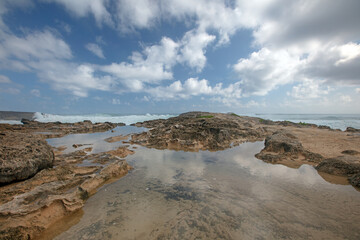 Tidal pool at Laie Point rocky coastline with storm surf crashing at Kaawa on the North Shore of Oahu Hawaii United States