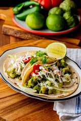 Tacos. Crispy flour and corn tortillas filled with sausage, bacon, beef, cheese, sour cream, salsa and guacamole and served with rice and beans. Classic Tex-Mex or Mexican restaurant entrée favorite.