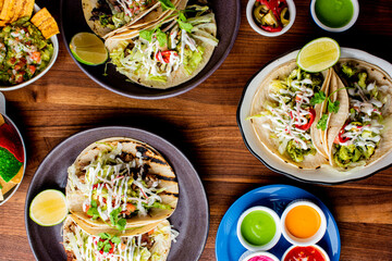 Tacos. Crispy flour and corn tortillas filled with sausage, bacon, beef, cheese, sour cream, salsa and guacamole and served with rice and beans. Classic Tex-Mex or Mexican restaurant entrée favorite.