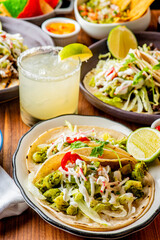 Tacos. Crispy flour and corn tortillas filled with sausage, bacon, beef, cheese, sour cream, salsa and guacamole and served with rice and beans. Classic Tex-Mex or Mexican restaurant entrée favorite.