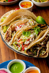 Tacos. Crispy flour and corn tortillas filled with sausage, bacon, beef, cheese, sour cream, salsa and guacamole and served with rice and beans. Classic Tex-Mex or Mexican restaurant entrée favorite.