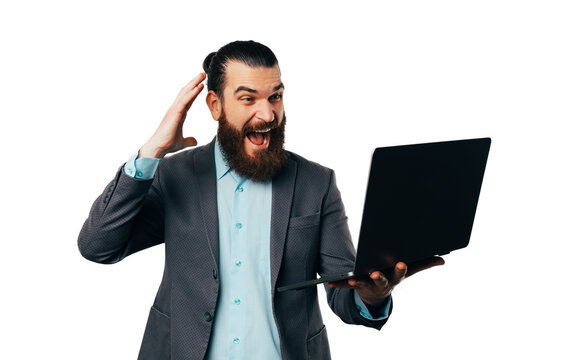 Screaming man is looking at the laptop he is holding over white background.