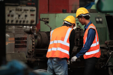 Fototapeta premium Supervisor Consults Young Engineer Working with big machine