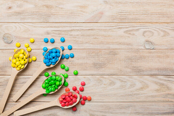 delicious colorful sweet candies on spoon on colored background . Confectionery decor top view with copy space