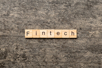FINTECH word written on wood block. FINTECH text on cement table for your desing, concept