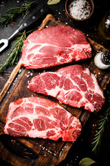 Raw pork steak on a wooden cutting board. 