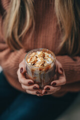 cocoa with marshmallows in female hands. girl in a sweater. warm christmas photo