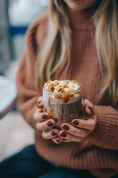 cocoa with marshmallows in female hands. girl in a sweater. warm christmas photo