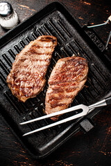 Aromatic grilled steak in a frying pan. 