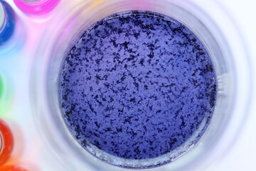 The surface of the reaction mixture where blue insoluble particles were formed in the beaker.
