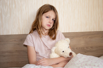 sick child holding his stomach. cute girl at home in quarantine due to illness. children get sick