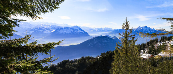 Massive Swiss Alps mountains towering over foggy misty Vierwaldstattersee, Lake Lucern, Rigi, Switzerland