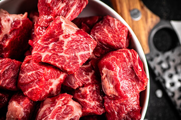 Sliced pieces of raw beef in a bowl.