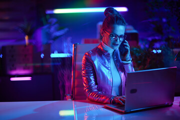 stylish business woman using laptop and using smartphone